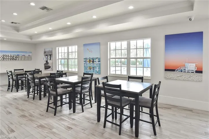 Dining area with a raised ceiling, crown molding, and light wood-type flooring