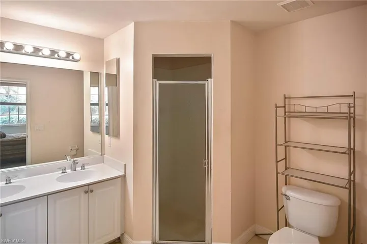 Bathroom with vanity, toilet, and an enclosed shower