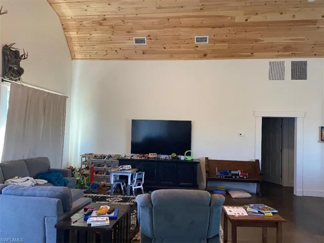 Living room featuring wood ceiling and high vaulted ceiling