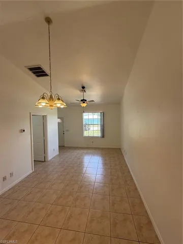Spacious interior featuring vaulted ceilings and neutral-toned ceramic tile flooring