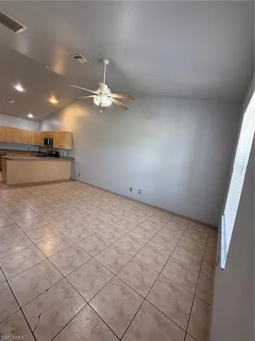 Open-concept living area with neutral tile flooring