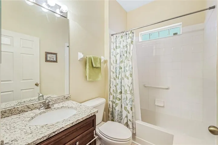Full bathroom featuring vanity, toilet, and shower / bathtub combination with curtain