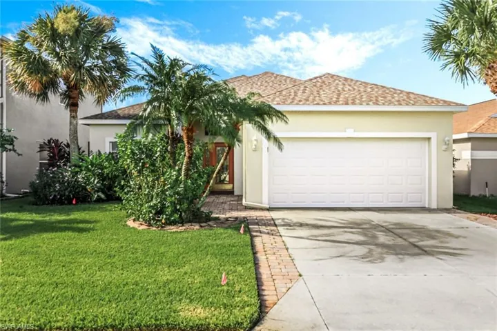 View of front of home with a garage and a front lawn