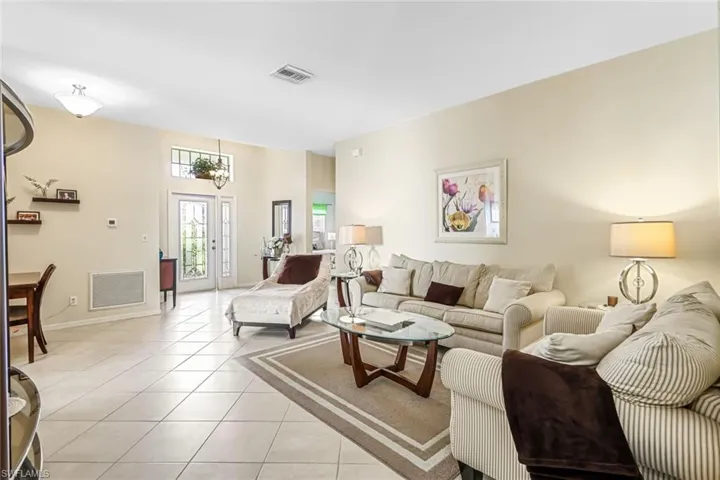 Tiled living room featuring french doors