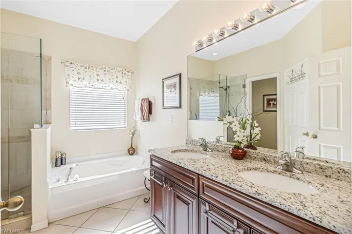 Bathroom featuring vanity, separate shower and tub, and tile patterned flooring