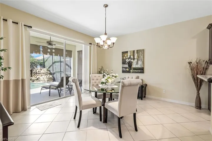 Dining area featuring ceiling fan with notable chandelier and light tile patterned flooring