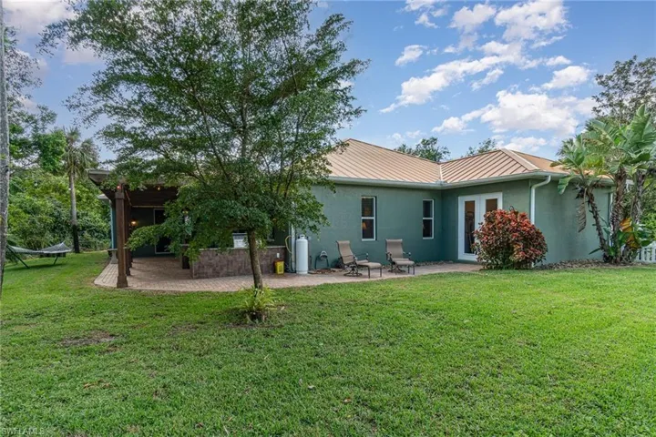 Back of property with a lawn and a patio