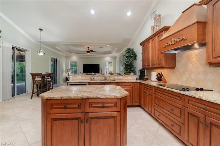 Kitchen with electric stovetop, crown molding, premium range hood, granite counter tops. Plenty of storage here!