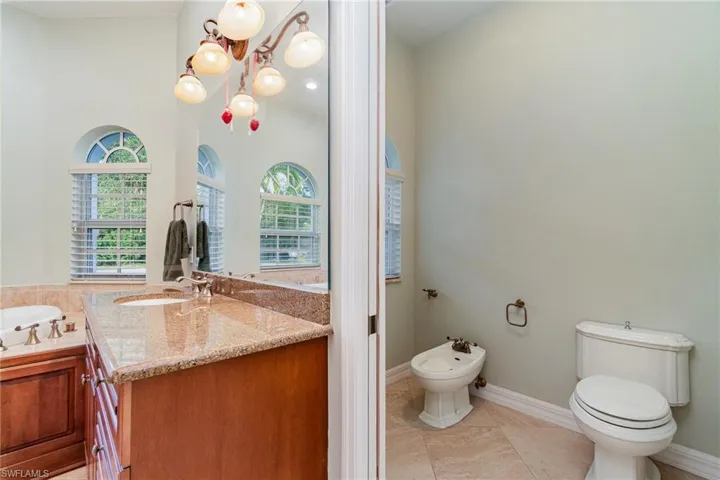 Bathroom with vanity, a bidet, tile floors, toilet,  wood cabinets