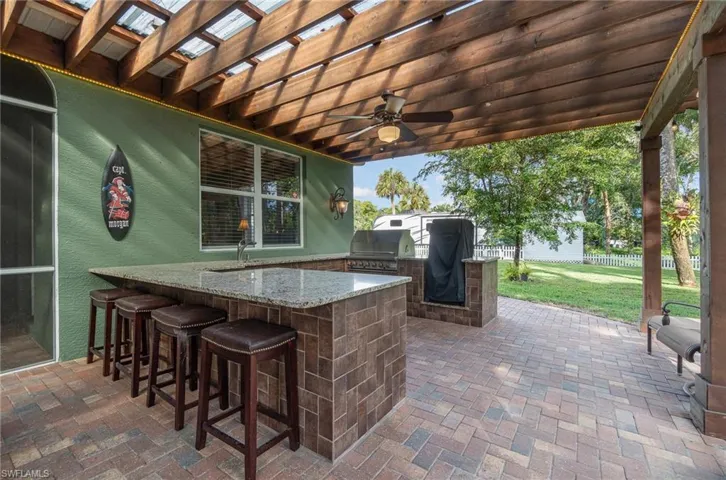 View of patio / terrace featuring area for grilling, ceiling fan, and view of side yard