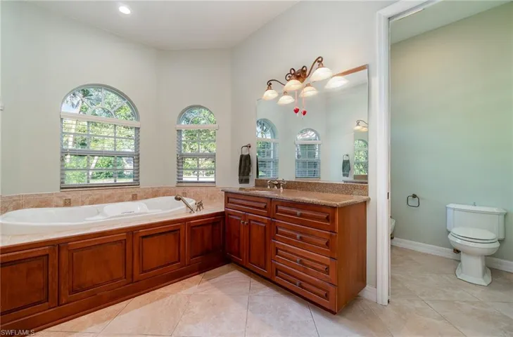 Bathroom featuring jetted tub and one of 2 vanities