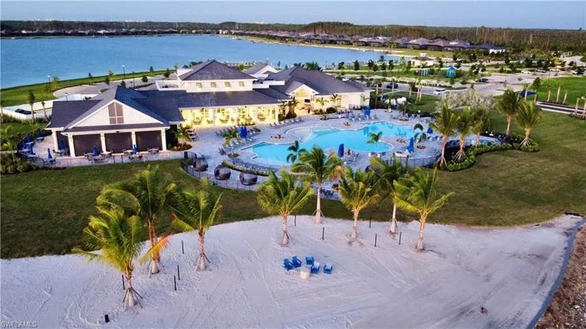 Aerial view of property and surrounding area featuring a pool area and a nearby body of water