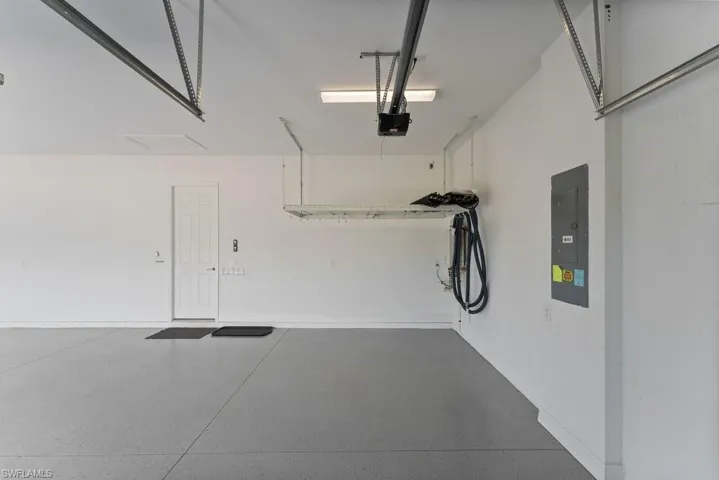 Garage featuring electric panel and a garage door opener
