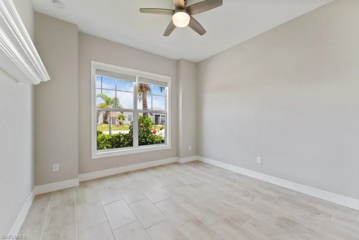 Spare room with a ceiling fan, baseboards, and a smoke detector