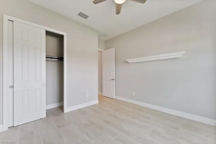 Unfurnished bedroom featuring a closet, ceiling fan, and baseboards