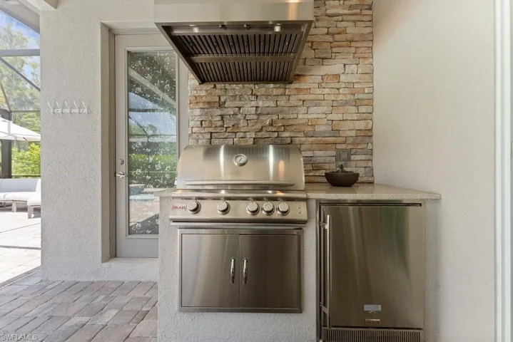 View of patio with area for grilling and glass enclosure