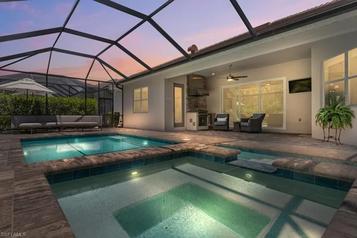 View of pool featuring outdoor lounge area, a patio, a ceiling fan, and a lanai