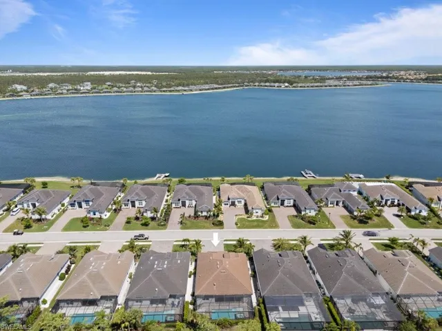 Aerial view of property and surrounding area with nearby suburban area and a nearby body of water