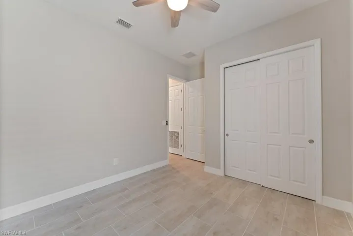 Unfurnished bedroom featuring a closet, baseboards, ceiling fan, and light wood finished floors