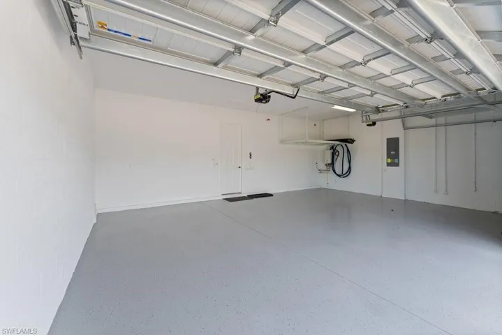 Garage with electric panel and a garage door opener