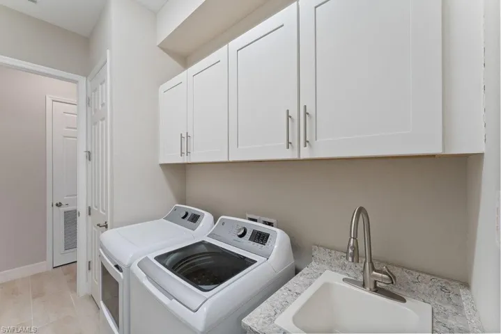 Washroom with washer and clothes dryer and cabinet space