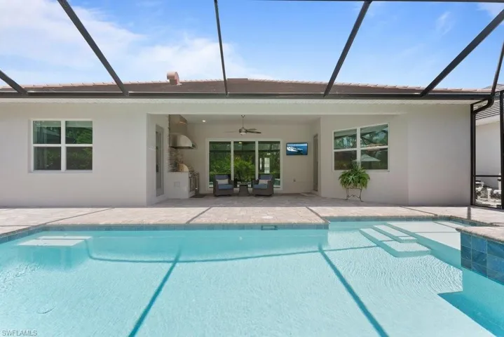Swimming pool with a ceiling fan, a patio, and a lanai