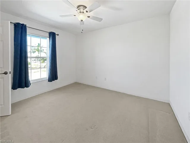 Guest bedroom with light carpet and a ceiling fan