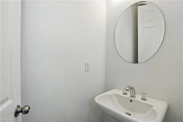 Pedestal sink with chrome faucet and clear acrylic handles