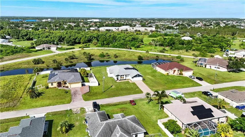 Aerial perspective showcasing multiple properties, residential streets, and a prominent canal
