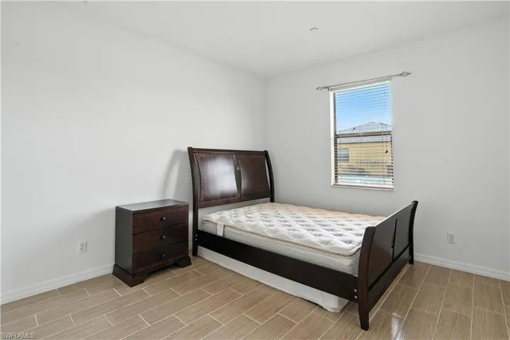 Bright room featuring light-toned tile flooring and a window with horizontal blinds
