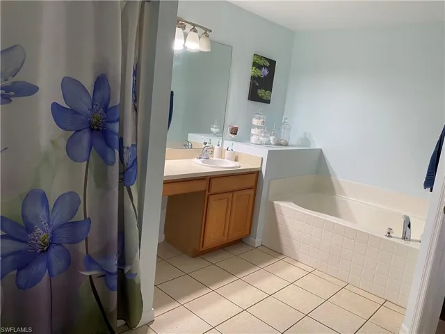 Bathroom featuring vanity, tile patterned floors, and a garden tub