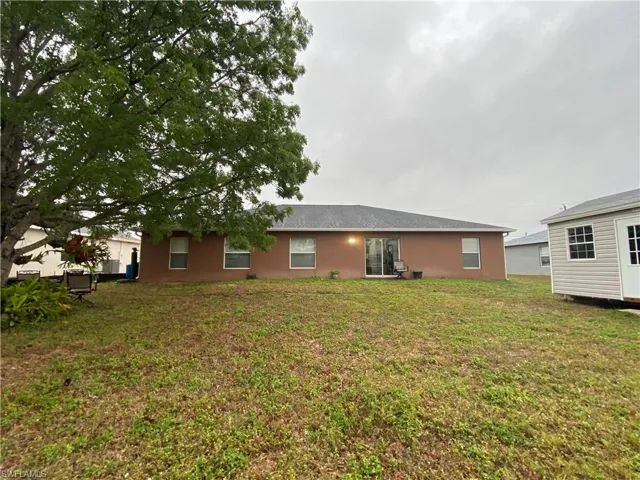 Back of house with a lawn
