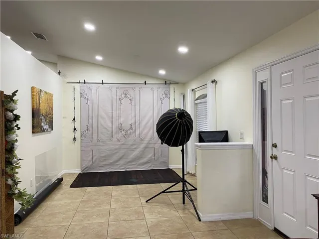 Tiled entrance foyer featuring lofted ceiling, recessed lighting, visible vents, and baseboards
