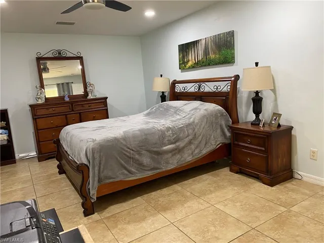 Bedroom with a ceiling fan, visible vents, baseboards, light tile patterned flooring, and recessed lighting