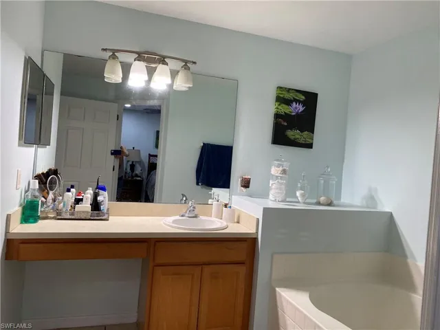Bathroom with a bath, ensuite bath, and vanity