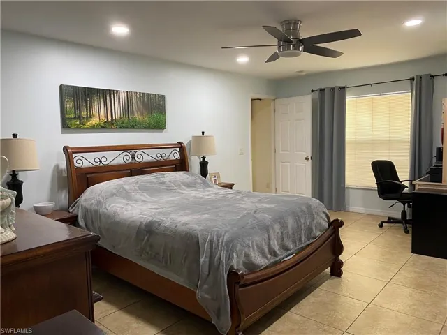 Bedroom with a ceiling fan, light tile patterned flooring, and recessed lighting