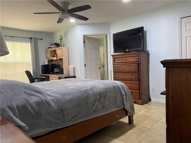 Bedroom featuring baseboards, light tile patterned flooring, and a ceiling fan