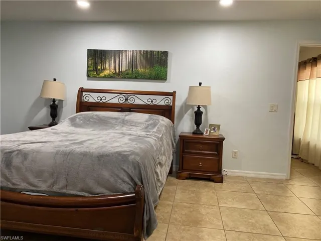 Bedroom featuring light tile patterned floors, baseboards, and recessed lighting
