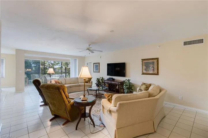 Living area featuring light tile patterned flooring and ceiling fan