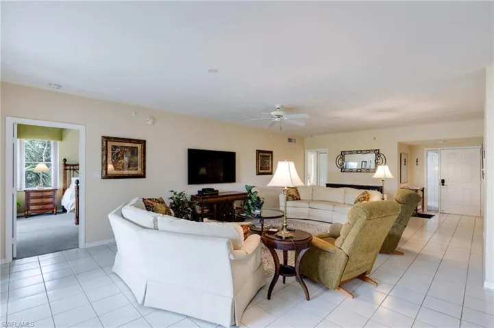 Living room featuring light tile patterned floors and ceiling fan