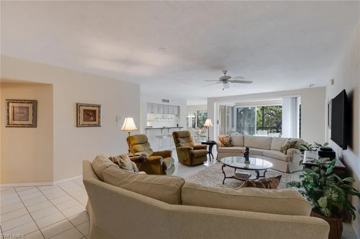 Living room featuring light tile patterned flooring and a ceiling fan