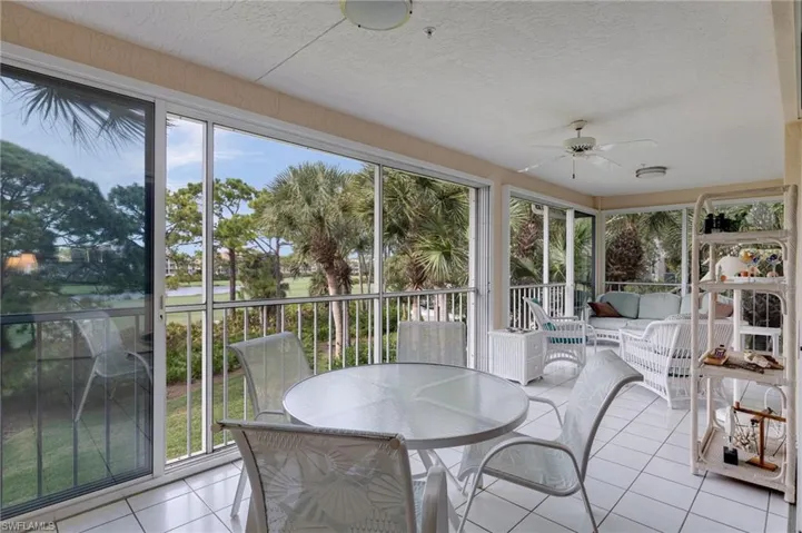 Sunroom with tile patterned floors and a water view