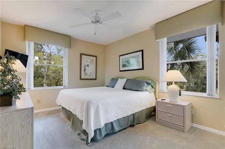 Bedroom with light carpet and a ceiling fan