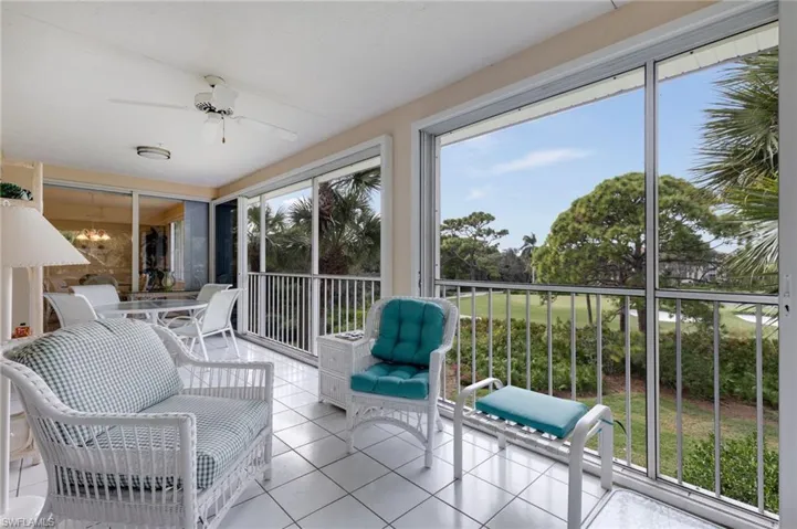 Sunroom / solarium with tile patterned flooring and a chandelier