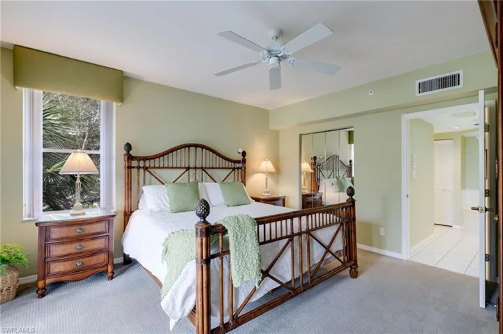 Bedroom with light colored carpet, a closet, and ceiling fan