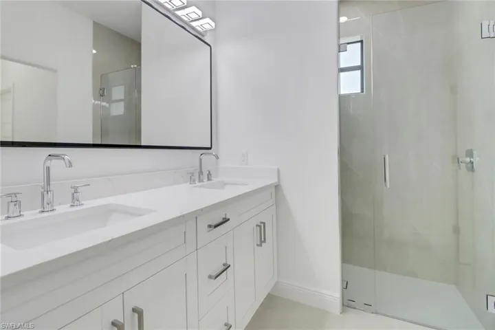 Main bath with double vanity and an enclosed shower