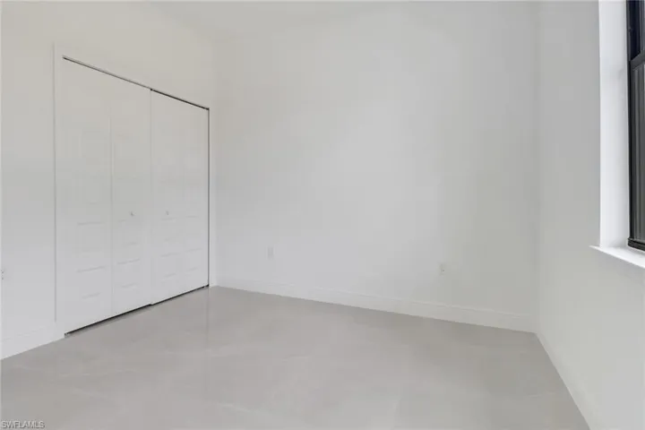 Guest bedroom with a closet and light tile patterned flooring