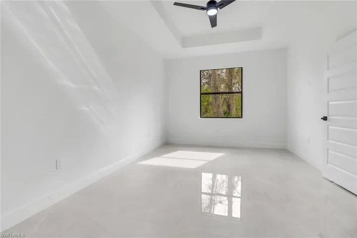 Main suite featuring ceiling fan and a raised ceiling