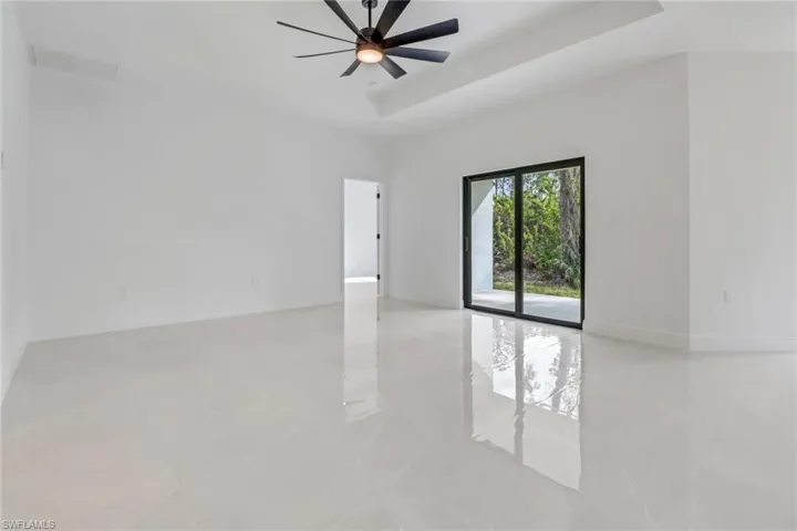 Living room with ceiling fan and a raised ceiling
