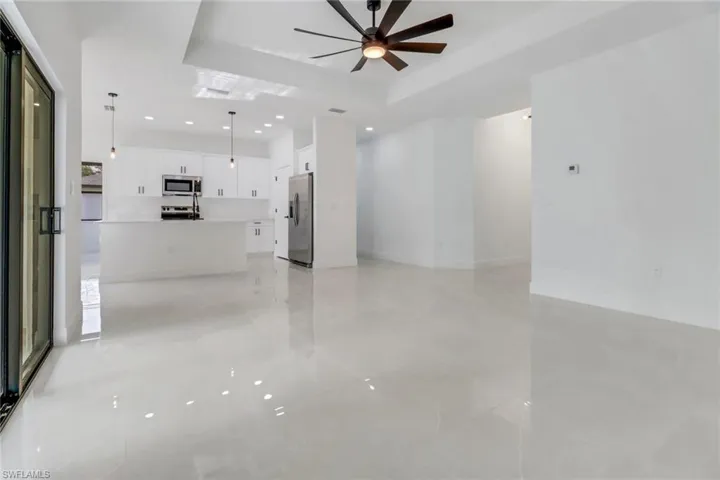 Living room featuring ceiling fan and a tray ceiling
